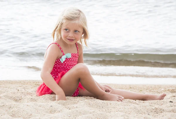 Маленькая девочка загорает на пляже — стоковое фото