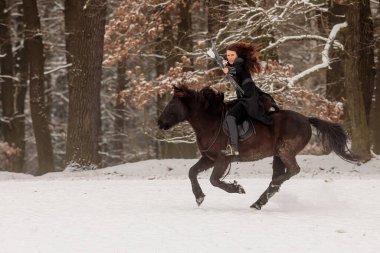 Bir savaşçı gibi tarihi bir kostüm giymiş bir kadın ok atmak istiyor.