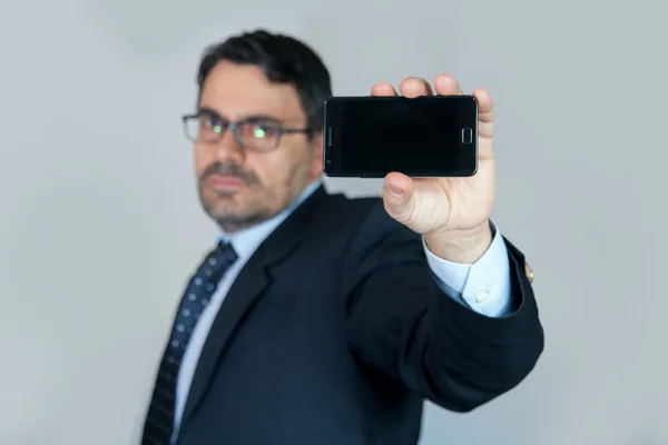 Чоловік в офісі зі смартфоном — стокове фото