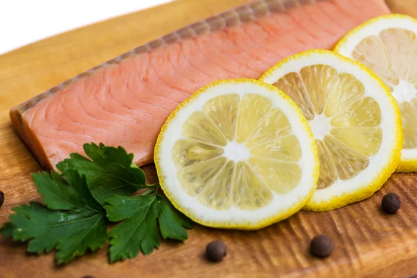 Raw salmon fillet with lemon, black pepper and parsley on a board — Stock Photo, Image