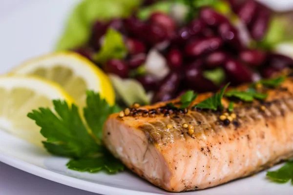 Salmon fillet grilled with bean salad, lemon and parsley — Stock Photo, Image