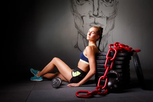 Jovem mulher atraente sentar-se na flor com equipamentos esportivos — Fotografia de Stock