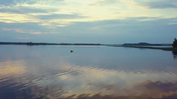 Increíblemente hermosa puesta de sol en el lago, el mar. La superficie del espejo del agua refleja los rayos del sol. Calma. Disparos con drones — Vídeos de Stock