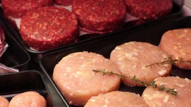 Masové hovězí. Tradiční americké jídlo. Mys na hamburgery. Cutlets leží na černém pozadí ve výloze obchodu. Zpomal. Rozepnout — Stock video