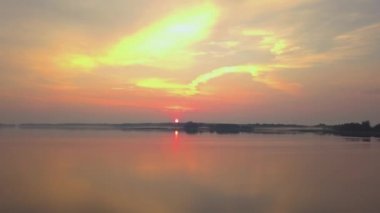 Güzel bir sabah. Sis, portakal rengi şafakta, suyun üzerinde. 4K insansız hava aracı görünümü