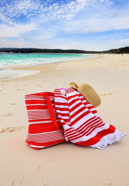 Bolsa de playa toalla y sombrero en la arena — Foto de Stock