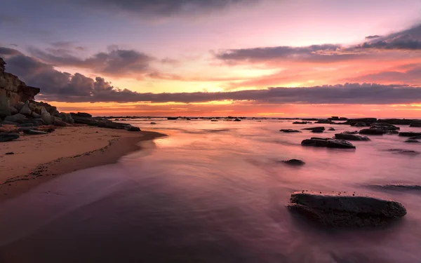 Magnificent sunrise high tide at Bateau Bay rockshelf — Stock Photo, Image