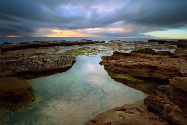 Alba tempestosa su Little Bay con piscina rocciosa in primo piano — Foto Stock