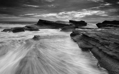 Avustralya 'daki Culburra Sahili' nde kayaların üzerinden geçen akıntıların güzel bir şekilde hareket etmesi için okyanus dalgalanması.