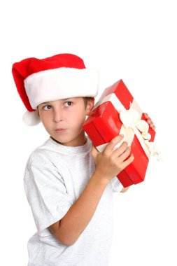 Meraklı çocuk Noel hediyesinin içeriğini merak ediyor. Beyaz arkaplan.