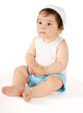 Beyaz bir arka planda dokuz aylık bir kız çocuğu oturuyor...