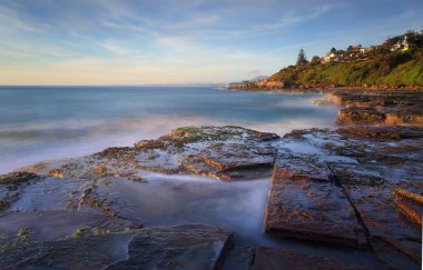Gün doğumundan hemen sonra Wombarra'daki kayalıklardan güneye bak. Uzun Pozlama.