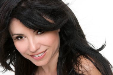 Rüzgarlı esmer saçlı oldukça gülümseyen bir kadının yüzü