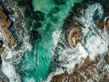 Dalgıcın biri dalganın üzerine çıktı. Kayaları süpürdü. Diz boyu topuklu bir kadın ayakkabısı taşıyordu.