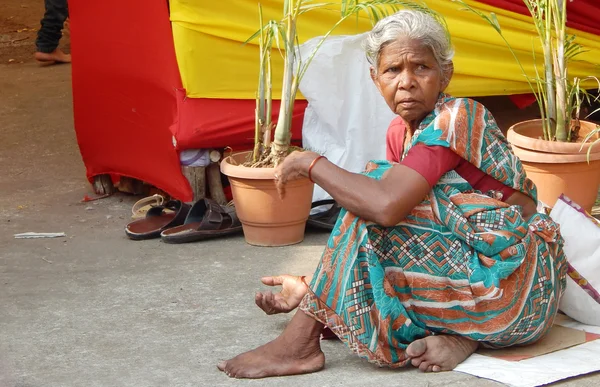 Stackars indisk kvinna söka hjälpa utomhus framför ett hinduiskt tempel — Stockfoto