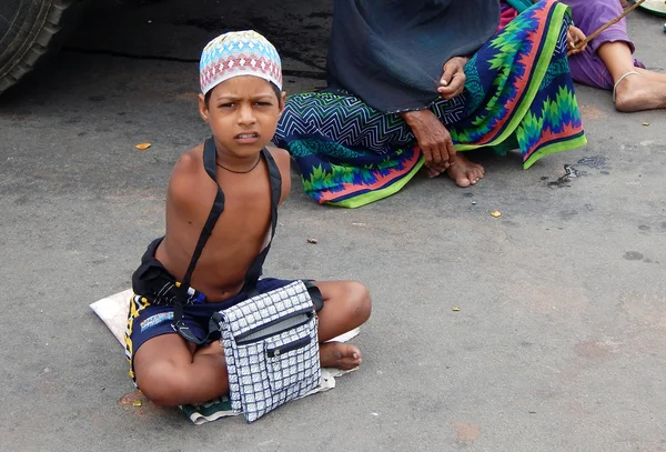 Chico con discapacidad física en busca de ayuda o mendigar en la carretera ocupada — Foto de Stock
