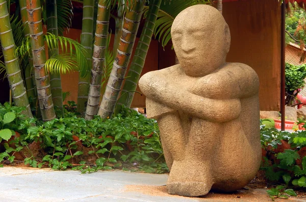 stock image View of a stone carved man figurine sitting on floor and thinking                               