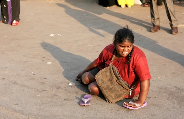 Hintli kadın kıdemli işlek bir yol yalvarıyor — Stok fotoğraf