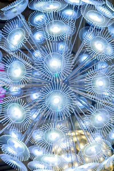 Parlayan karahindiba çiçeklerine benzeyen soyut bir açık hava ışık kurulumunun yakın görüntüsü. Parlak LED ışıklar modern, fütüristik ve sanatsal bir atmosfer yaratır, tasarım, teknoloji ve yaratıcı kavramlar için mükemmeldir.