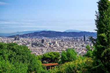 Montjuic 'ten Barselona şehrine tepeden bakan panoramik manzara. Önplanda yoğun binalar var.