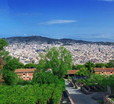 Montjuic 'ten Barselona şehrine tepeden bakan panoramik manzara. Önplanda yoğun binalar var.