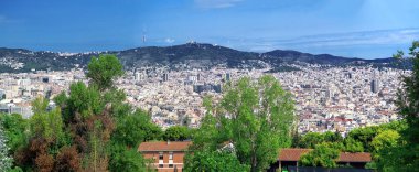 Montjuic 'ten Barselona şehrine tepeden bakan panoramik manzara. Önplanda yoğun binalar var.
