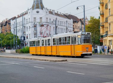 Budapeşte, Macaristan - 3 Ağustos 2018: Şehir taşımacılığı altyapısı ve günlük seyahat rutinini gösteren sarı tramvay