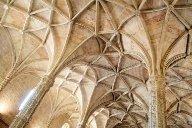 Karmaşık taş kubbeli tavanın detaylı bir görüntüsü. Tarihi bir yapıda tırtıklı kemerler, çiçek patronları ve oyulmuş sütunlar. Mimari miras, turizm pazarlaması, iç tasarım ve lüks markalaşma uygulamaları için ideal