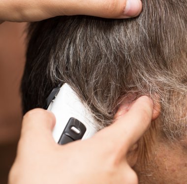 saç kesme makineleri ile bir saç kesimi olan bir erkek öğrencinin yakın çekim