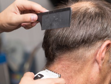 saç kesme makineleri ile bir saç kesimi olan bir erkek öğrencinin yakın çekim