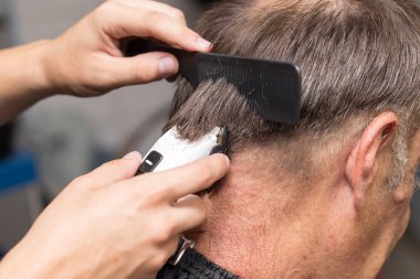 saç kesme makineleri ile bir saç kesimi olan bir erkek öğrencinin yakın çekim