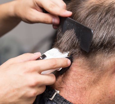 saç kesme makineleri ile bir saç kesimi olan bir erkek öğrencinin yakın çekim