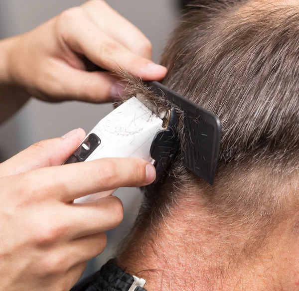 Primer plano de un estudiante masculino que tiene un corte de pelo con cortadores de pelo —  Fotos de Stock