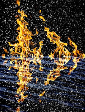 Ateş arkaplanındaki kar suya yansıyor