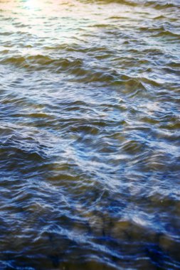 Gökyüzü ve bulutlar su yüzeyine dalga dalga yansıyor.