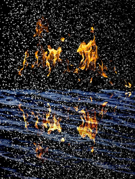 Sníh na pozadí ohně s odrazem na vodě — Stock fotografie