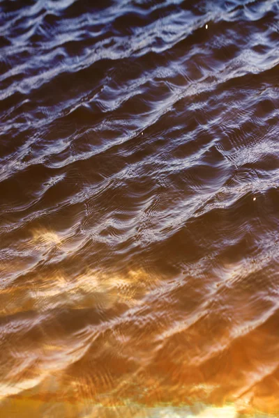 Céu com nuvens refletidas na superfície da água com ondas — Fotografia de Stock