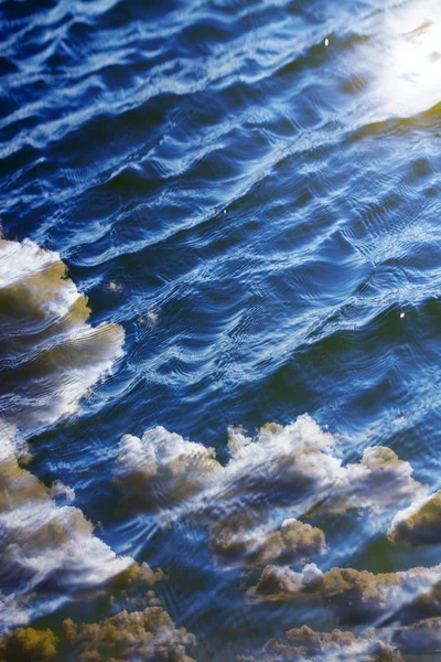 Sky with clouds reflected on the water surface with waves — Stock Photo, Image