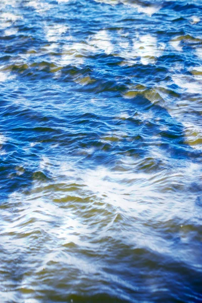 Cielo con nubes reflejadas en la superficie del agua con olas — Foto de Stock
