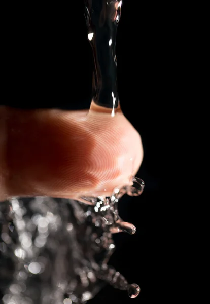 Finger i vatten på en svart bakgrund — Stockfoto