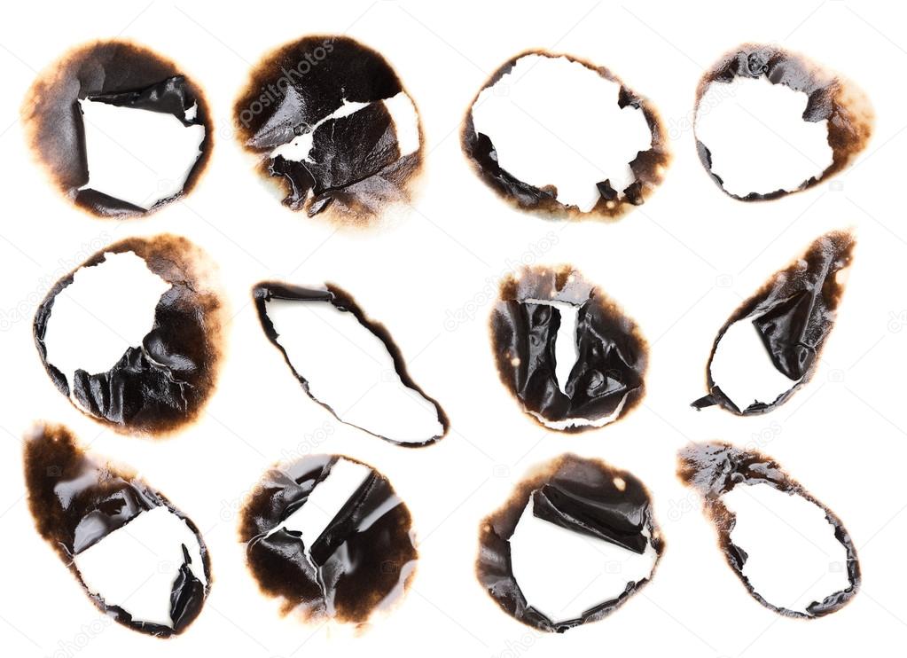 Collection of burnt holes in a piece of paper isolated on white 