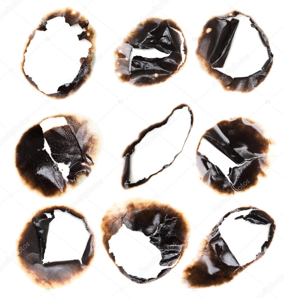 Collection of burnt holes in a piece of paper isolated on white 