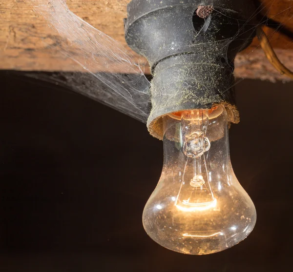 Gammal lampa brännande på ett trätak — Stockfoto