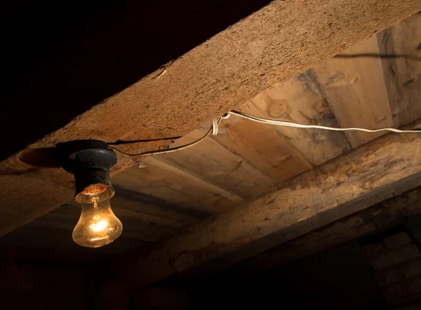 Стара лампа, що горить на дерев'яній стелі — стокове фото