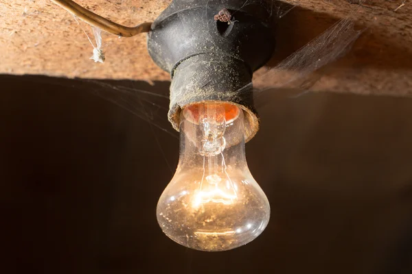 Gammal lampa brännande på ett trätak — Stockfoto