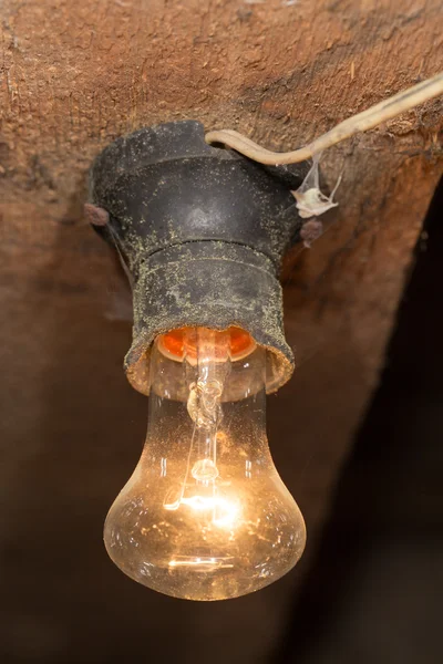 Oude lamp branden op een houten plafond — Stockfoto