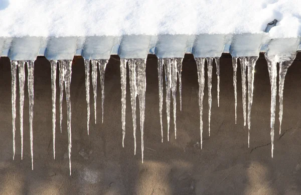 Eiszapfen, die von einem Dach herabhängen. — Stockfoto