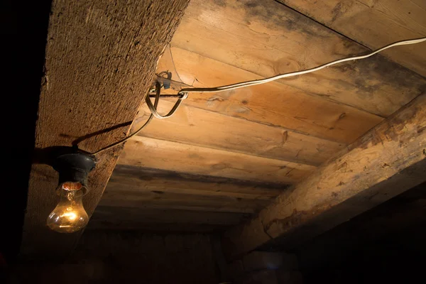 Старая лампа горит на деревянном потолке — стоковое фото