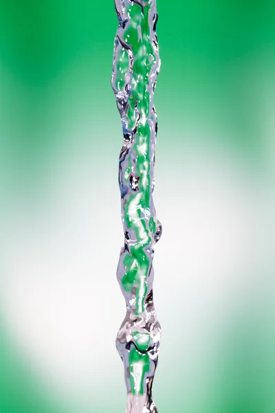 A jet of water on a green background — Stock Photo, Image