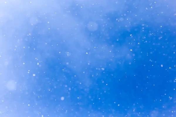 Nevicando su un cielo blu — Foto Stock